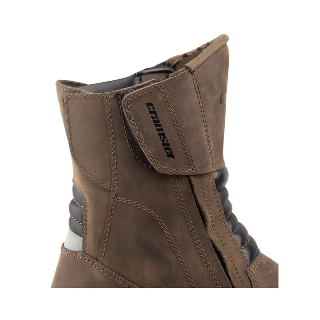 Brown suede boot side view with adjustable strap and black inner laces/lining detail