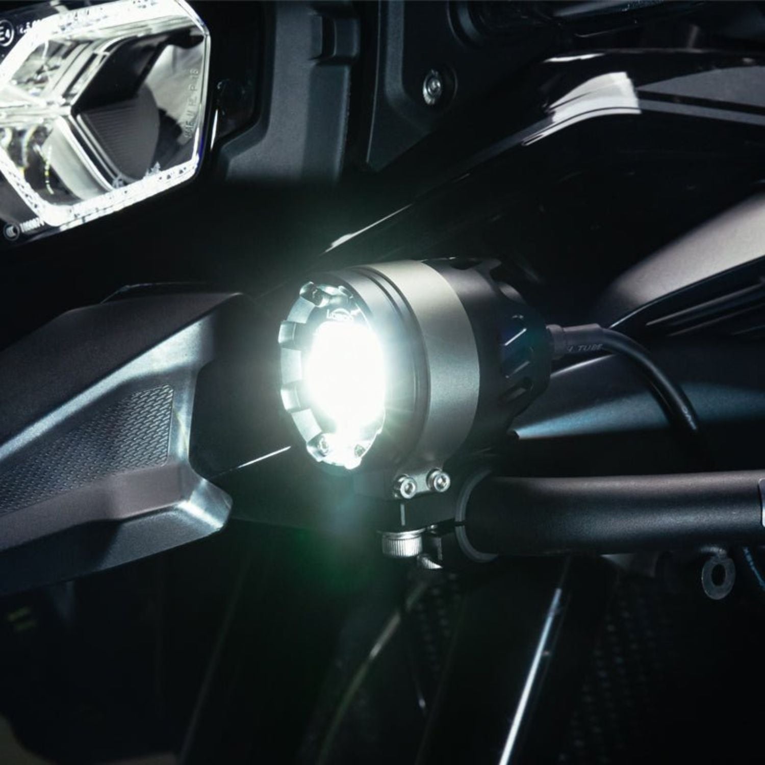 Loboo L75 auxiliary light switched on, bright white beam from circular black housing