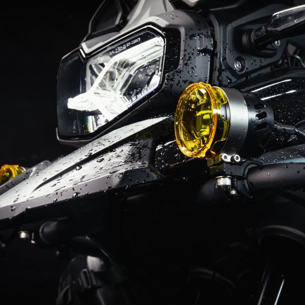 Loboo L75 auxiliary light mounted near headlight, glowing yellow lens on black bracket